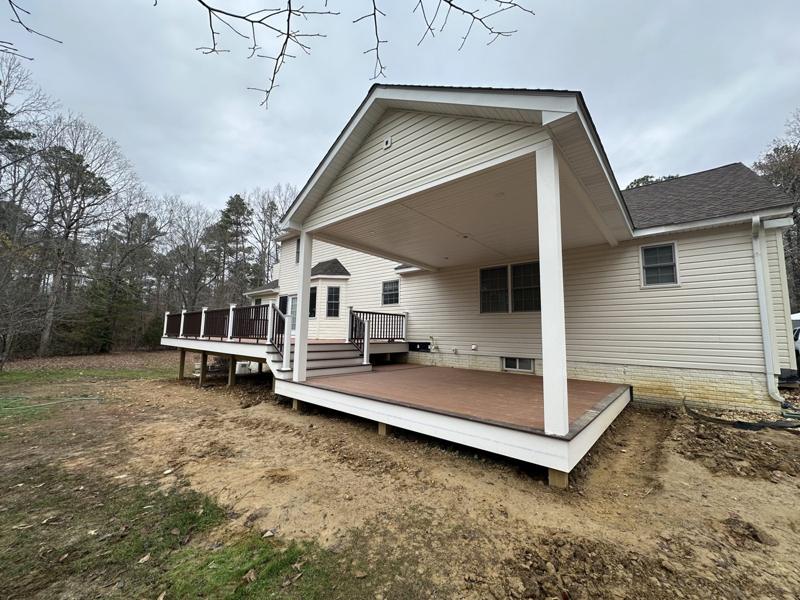 A finished covered porch with white columns