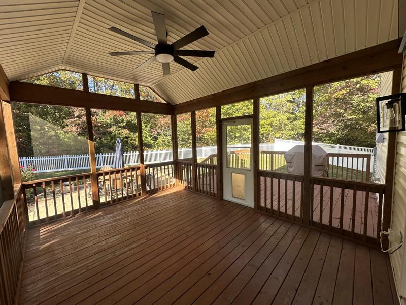 Inside a finished screened porch with a ceiling fan